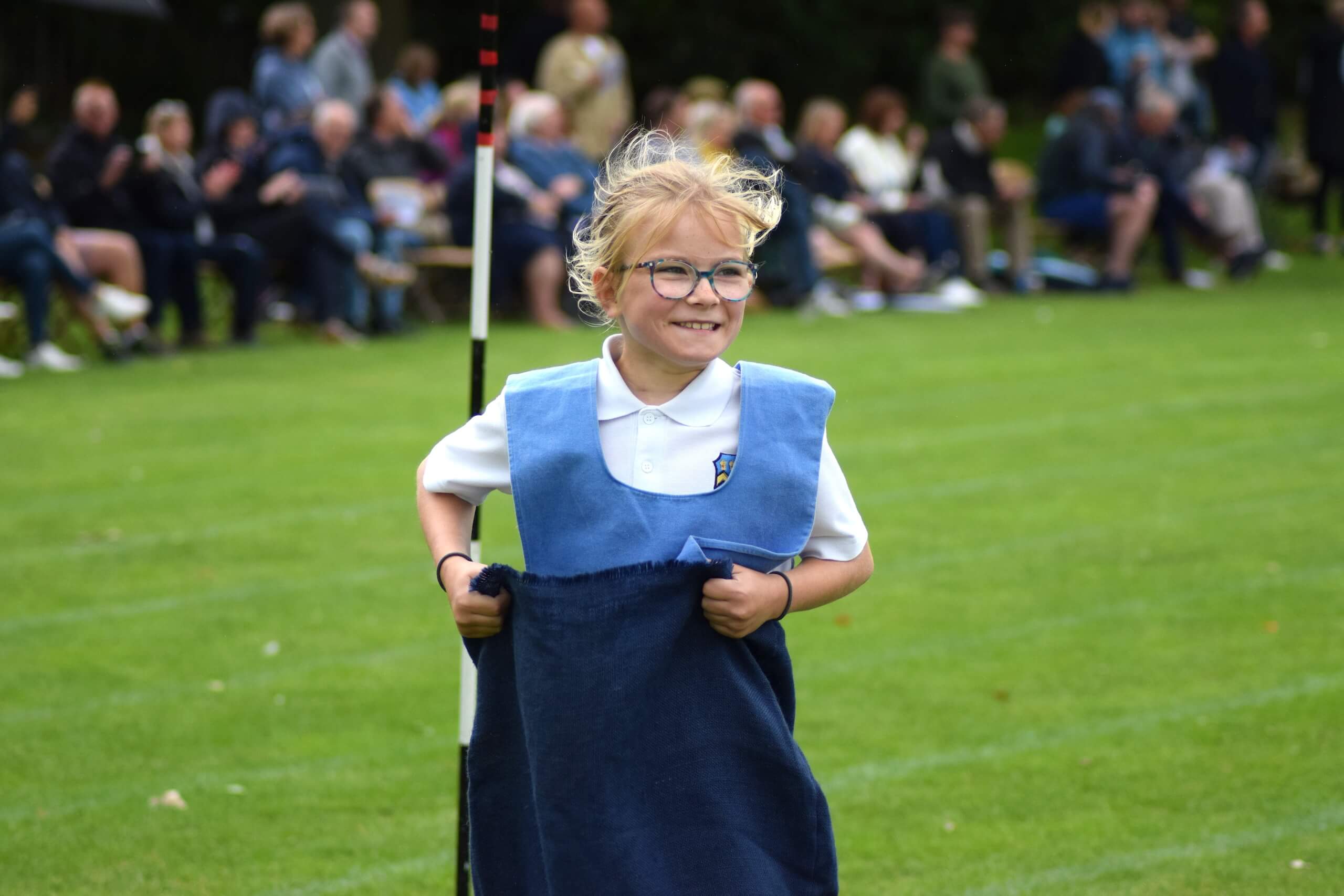 Pupil smiling in school sports day sack race at Pocklington Prep School a private day and boarding school in Yorkshire near York, Beverley and Hull