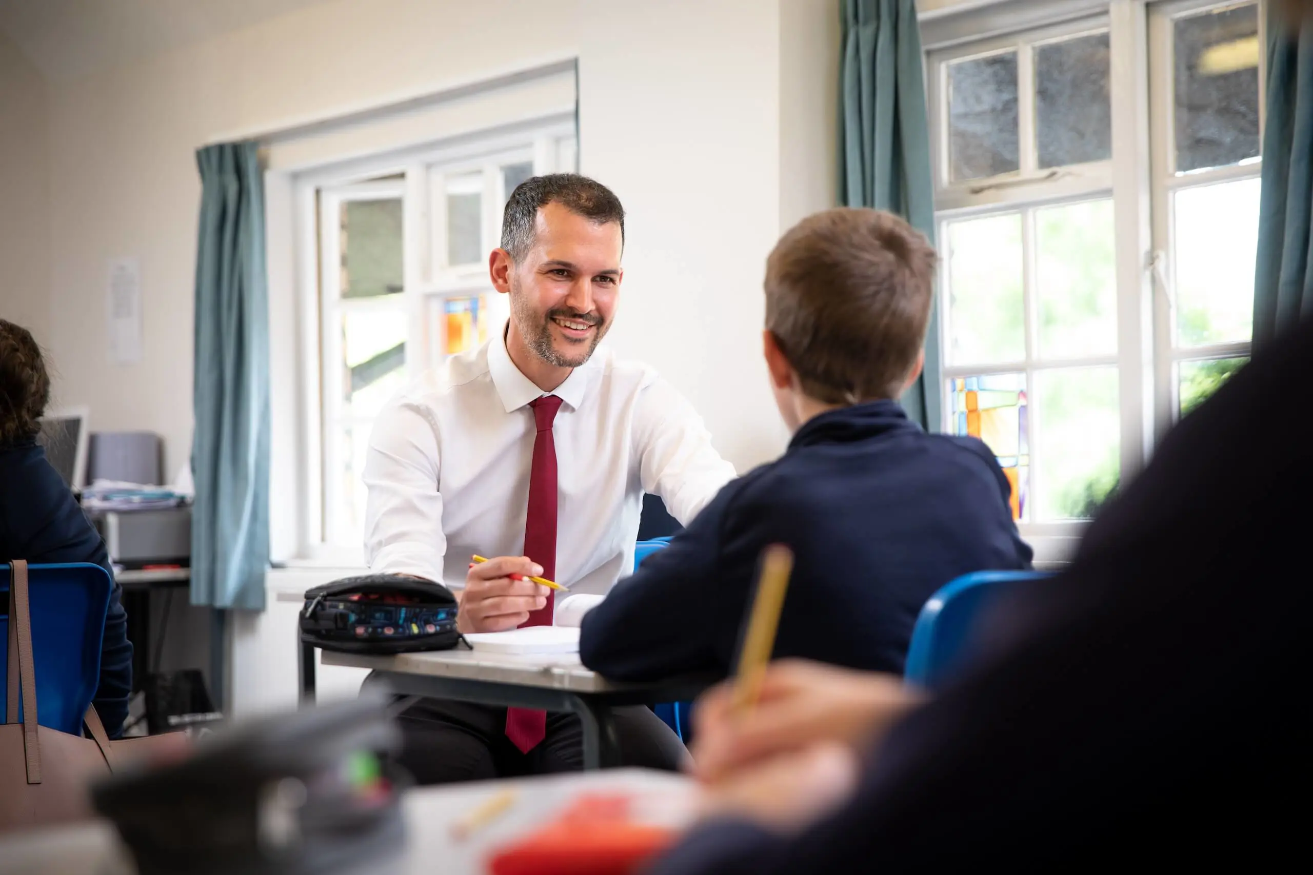 Pocklington student talking to maths teacher in classroom