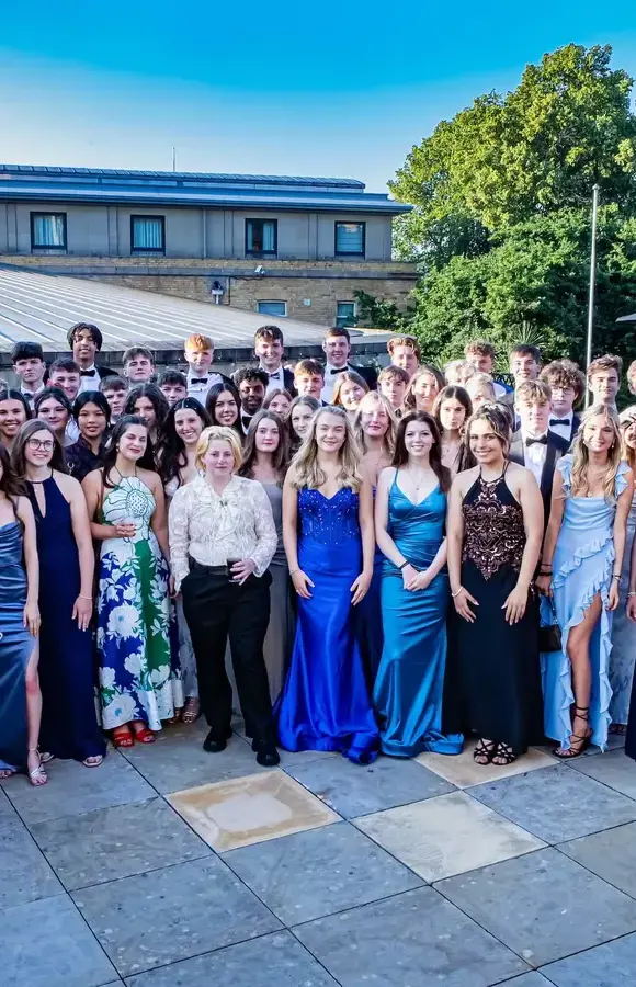 Sixth Form cohort in evening wear, stood outside in grounds of hotel at their Leavers Prom